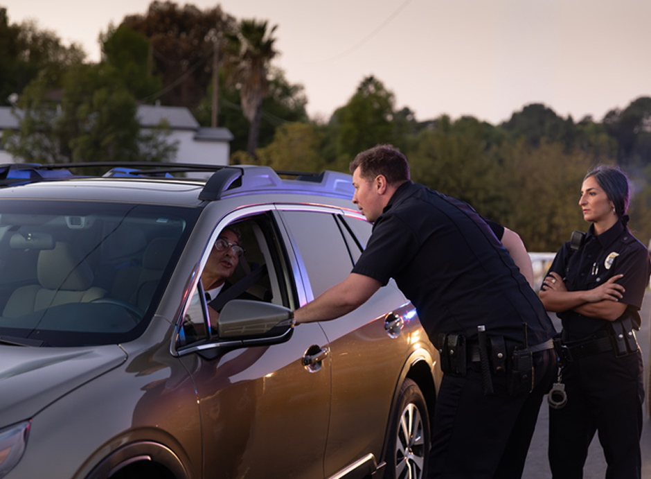Officers talking to driver at sunset