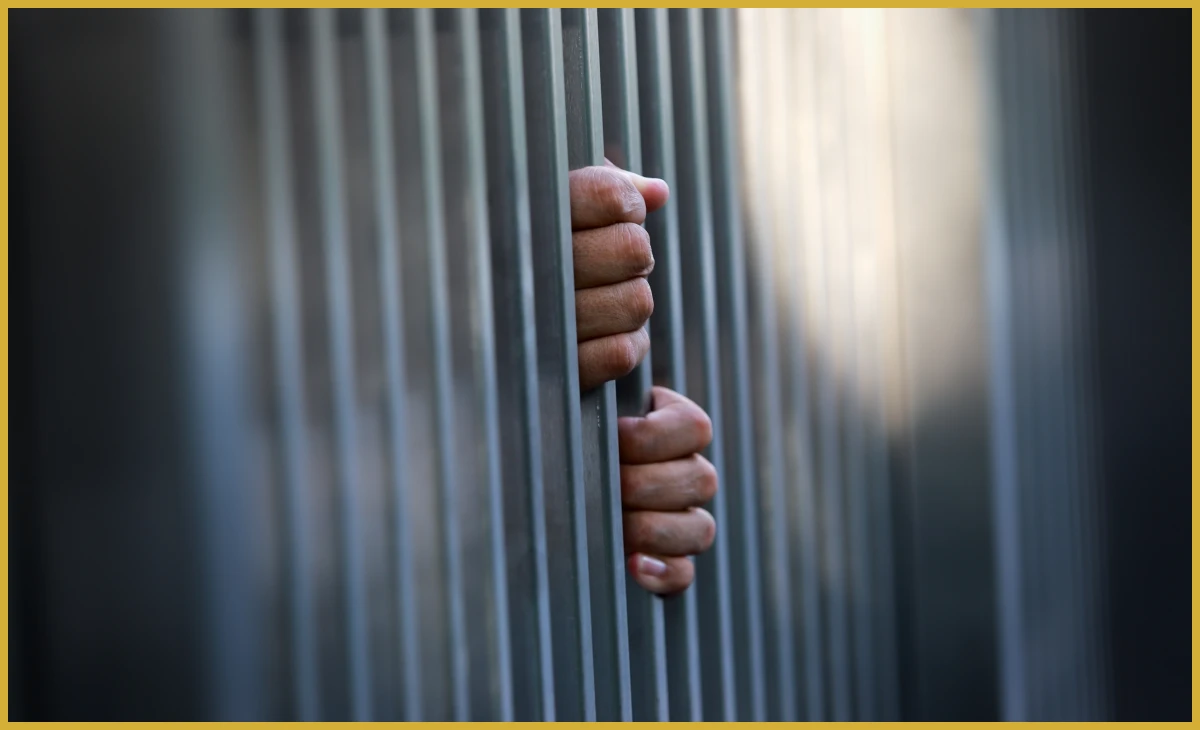 Hands clasped around metal bars
