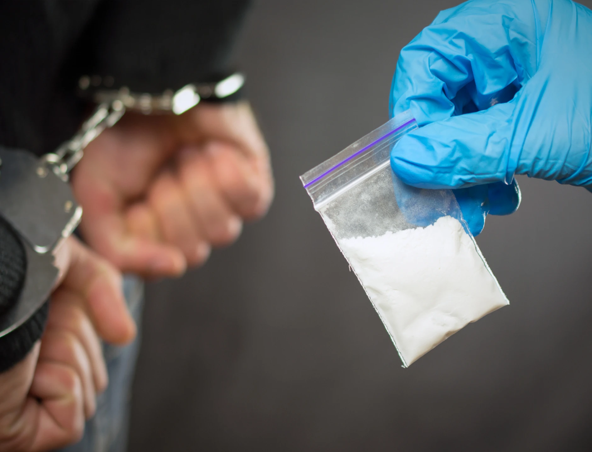 Handcuffed suspect with drug evidence